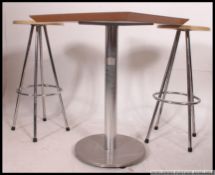 A retro style contemporary circular breakfast table raised on chrome tubular legs united by