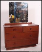 A mid century mahogany chest of drawers in the air ministry style raised on an inset plinth with