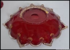 A collection of four early 20th century ruby glass candle sticks along with a similar bowl 30cm