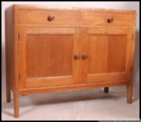 An excellent mid century Air Ministry golden oak sideboard of small proportions raised on tapered