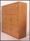 A contemporary 9 beech wood 9 drawer office filing locker cabinet raised on inset plinth base with