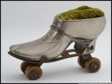 A rare and amusing white metal pin cushion in the form of an early 20th century roller skate and