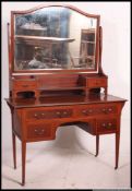 An Edwardian mahogany dressing table being raised on squared legs with a series of drawers and