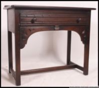 An Ercol Old colonial dark beech and elm wood side table / writing desk.