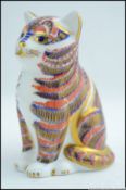 A Royal Crown Derby gold button figurine of a cat, with makers marks to base.