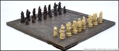 A vintage mid 20th century boxed Chinese resin chess set complete with chess board.