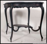 A Victorian ebonised mahogany centre / occasional table of rococo form having cabriole legs with
