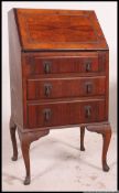 A 1930's walnut Queen Anne revival ladies writing bureau desk raised on cabriole legs with pad feet.