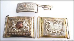 A collection of three Indian white metal (likely silver ) uniform belt buckles