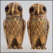 A pair of continental white metal silver ( stamped 800 ) gilt owl condiments with glass eyes.