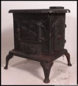 A large cast metal / iron wood burning stove ' The Comforter ' with ornate bird decoration,