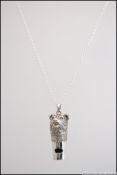 A white metal 925 silver whistle in the form of a dog on silver chain.
