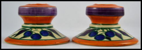 A pair of Art Deco Clarice Cliff Fantasque candlesticks marked to the base with additional markings