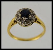 An 18ct gold sapphire and diamond ring having central round cut sapphire with illusion set diamonds