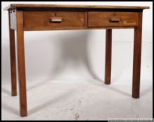 A mid century Air Ministry style oak desk raised on squared legs with a pair of fitted frieze