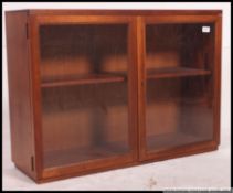 A retro 1960's teak wood hanging wall cabinet with glass sliding doors.