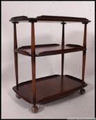 An Ercol Windsor dark elm and beech three tier trolley, on wheels, 72cm wide, 74cm high, 47cm deep.
