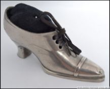 A vintage silver plated pin cushion in the form of a boot,