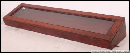 A good early 20th century shop display cabinet case of angular form with glazed opening cabinet