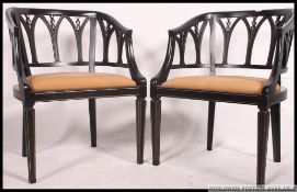 A pair of Regency revival ebonised and parcel gilt library chairs.