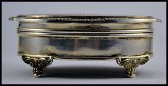 A silver hallmarked ladies jewellery trinket box raised on decorative feet having hinged top and