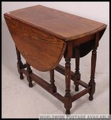 A 1930's golden oak barley twist drop leaf / gate leg dining table having solid oak table top above