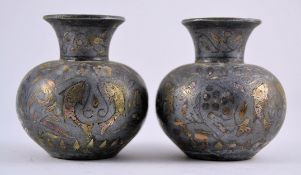 A pair of silver and pewter inlaid asiatic vases of stub form.