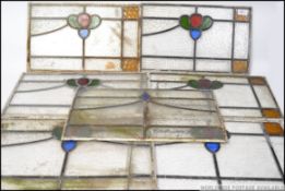 A collection of early 20th century stained glass panels having leaded glass surrounds.