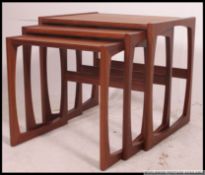 A retro 1970's G-Plan Kelso Nest of table in teak raised on squared supports having graduating tops