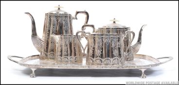 An early 20th century silver plated tea service being chase decorated to include teapot and coffee