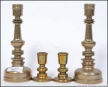 A pair of 20th century very heavy machine turned brass candle sticks along with another shorter