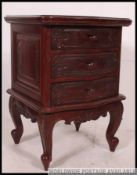 A 20th century rococo revival mahogany bedside chest of drawers.