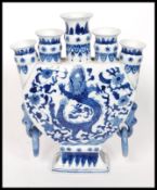 A Chinese blue and white five planter moon vase bearing dragons and tress to each side.