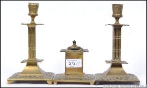A pair of Victorian brass candlesticks having single sconces together with a matching inkwell.