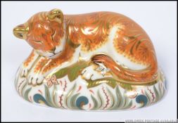 A Royal Crown Derby paperweight Sleepy Lion Cub with gold stopper.