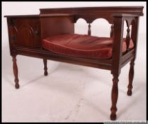 A 20th century Jacobean revival mahogany telephone table with single drawer and seat.