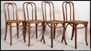 A set of four mid 20th century bentwood chairs in the manner of Thonet having cane seats.