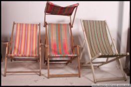 Three vintage mid 20th century folding deck chairs with alternating striped seats,