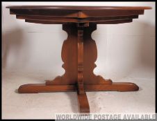 An Ercol Golden Dawn beech and elm wood circular large extending dining table.