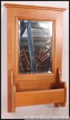 A contemporary American beech wood wall mirror with central glass over hinged toiletry box.