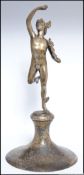 A cast pewter figure of Eros raised on a hand beaten bell shaped socle stamped to the base Hutton