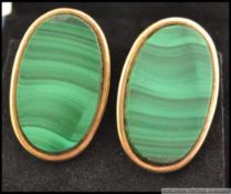 A pair of 9ct gold and malachite oval earrings - studs of large form being hallmarked to the verso.