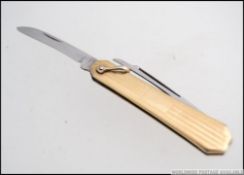 A good gold (tested to 9ct) but unmarked yellow metal handled miniature folding pen knife.