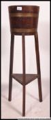 A Lister of Dursley style coopered barrell planter on raised legs with copper banding to the