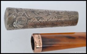 A 9ct gold rim cheroot in silver hallmarked rococo chased cheroot holder of tapered form,