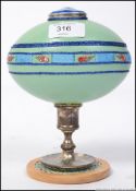 An unusual 20th century painted ostrich egg with hinged centre raised on white metal and wooden