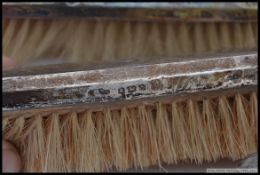 A silver hallmarked gentlemans clothes brush set being hallmarked together with the hand mirror.