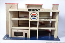 An original vintage wooden made childs toy garage with advertising slogans for Regent.