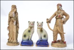 A pair of matching Staffordshire fireside cats along with a pair of Asiatic resin figures