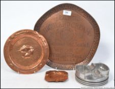 A 19th century Arts & Crafts copper dish being hand beaten with rose of England design.